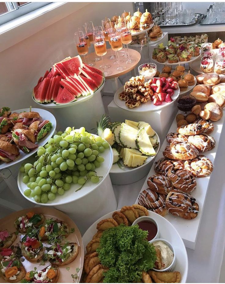 a table filled with lots of different types of food on plates and bowls next to each other