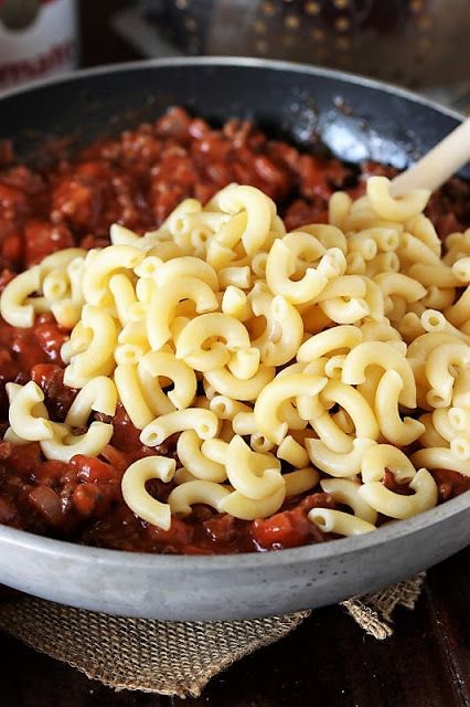 a bowl filled with noodles and meat on top of a table