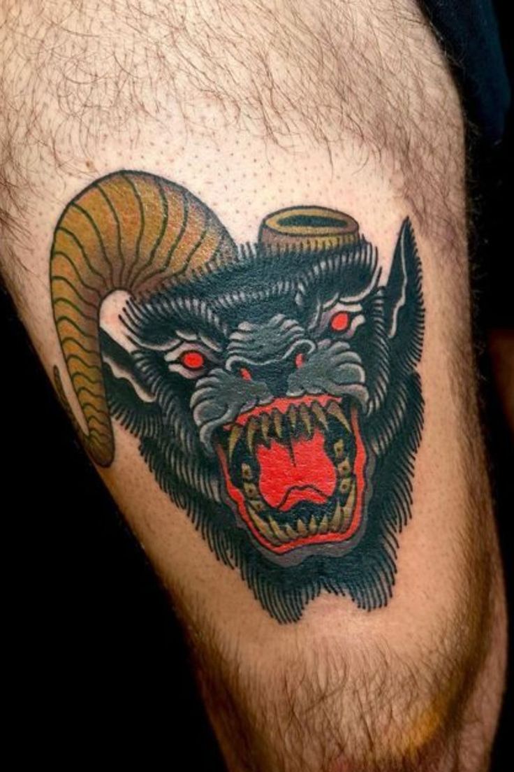 a man's leg with a tattoo on it that has an angry demon head