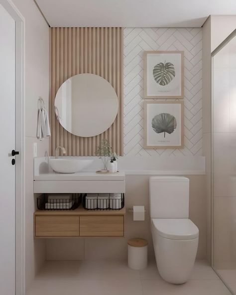 a white toilet sitting next to a bathroom sink under a round mirror on a wall