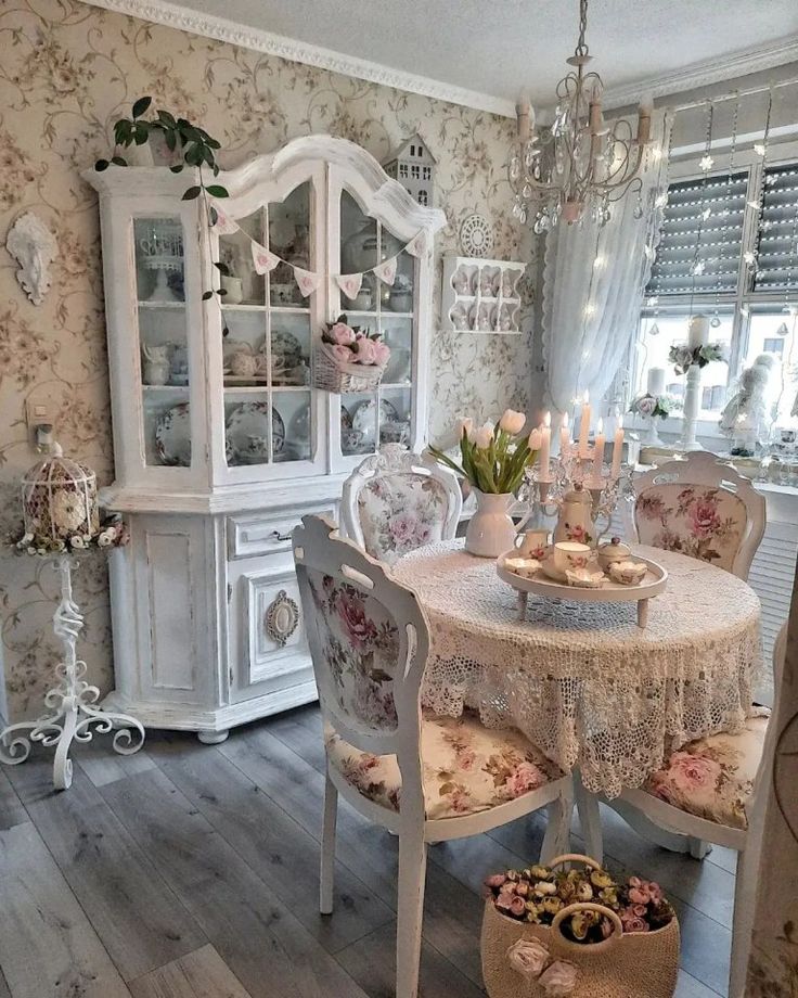 a dining room with white furniture and floral wallpaper