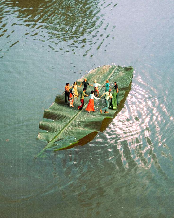 several people are standing on the edge of a boat that is floating in some water