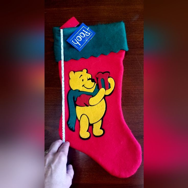 someone is holding up a christmas stocking with a bear on it