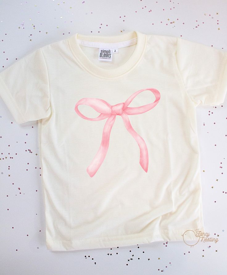 Our Pink Bow graphic tee is made with 100% polyester, ensuring durability and a comfortable fit. The cowboy design adds a fun and unique touch, making it perfect for any young adventurer. Upgrade their wardrobe with this high-quality tee today! *Don’t forget to choose your color tee: CREAM or WHITE *All tee brands run true to size. The graphic used on our tees are sublimation prints which means its printed into the fabrics on the shirt. No more peeling! *Care Instructions: Turn inside out & wash Cute Simple Shirt Designs, Cute Shirts Aesthetic Trendy, Making Graphic Tees, Bow T-shirt, Bow Tshirts, Pink Shirt Aesthetic, Pink Shirt Design, Coquette Wishlist, Mini Tees