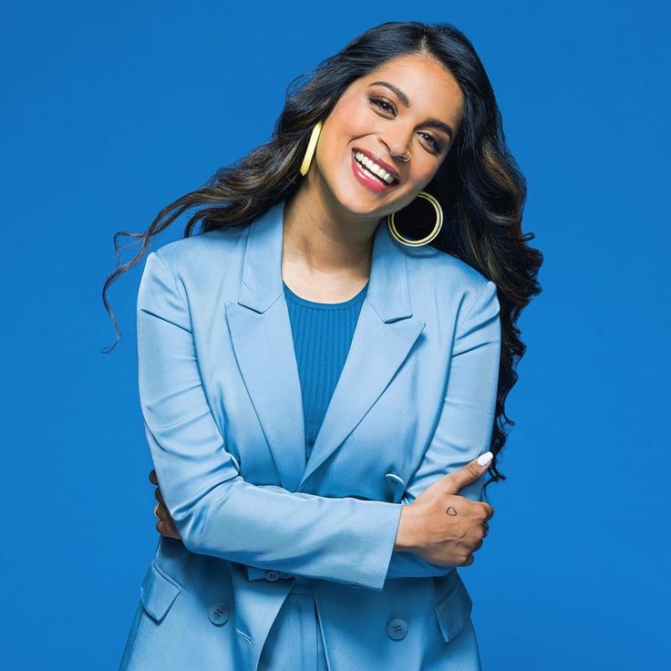 a smiling woman in a blue suit with her arms crossed