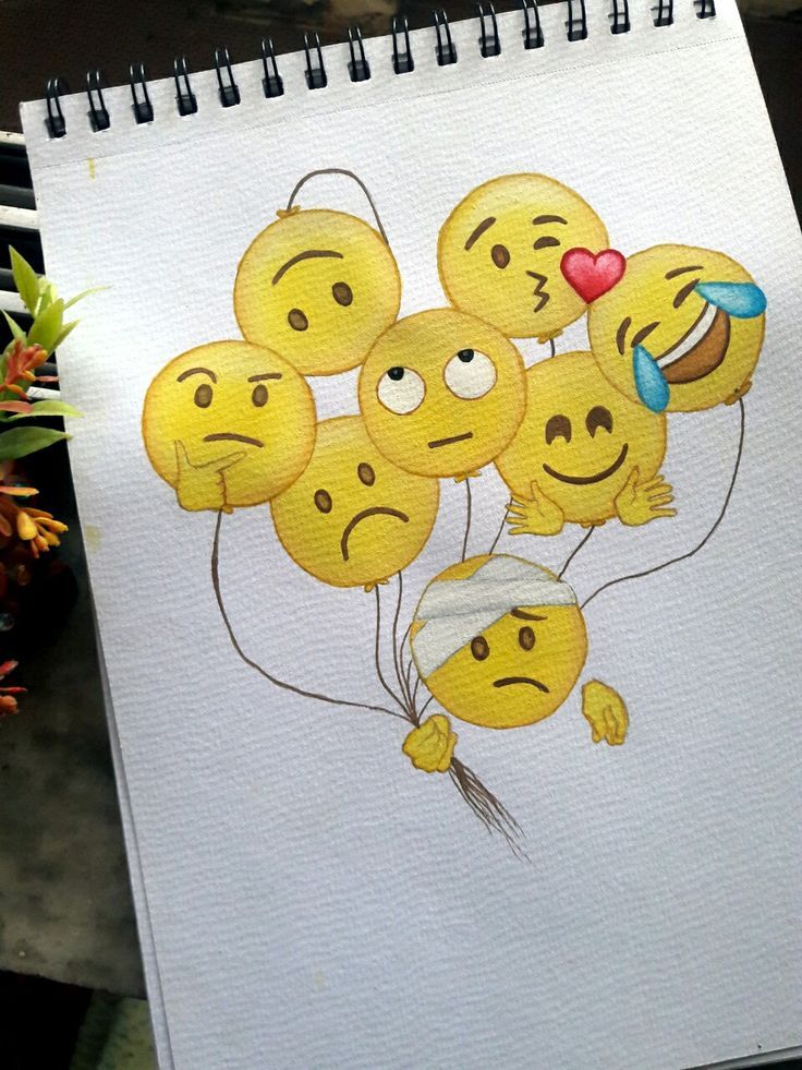 a drawing of some smiley face balloons on a white paper with flowers in the background