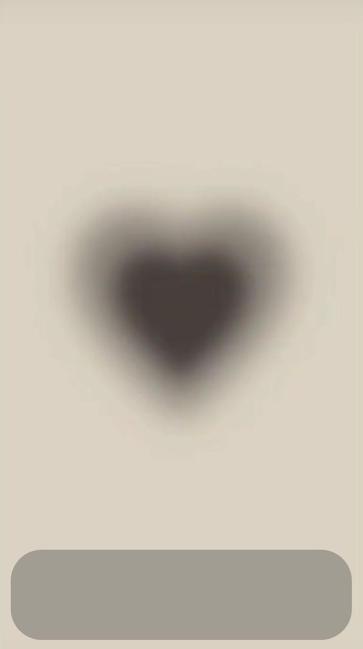 a heart shaped object is shown in the middle of a blurry image with gray and white colors