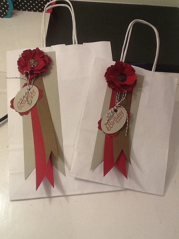 three bags with red flowers on them sitting on a table