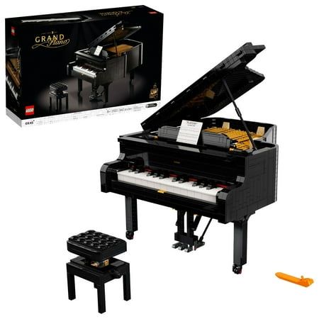 a lego grand piano and stool in front of a black box with the lid open