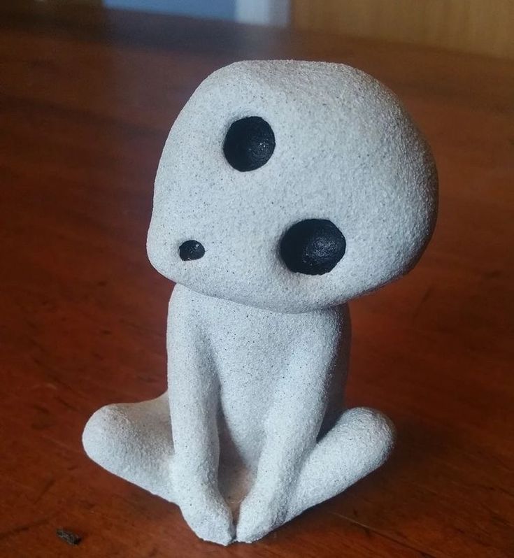 a small white toy sitting on top of a wooden table