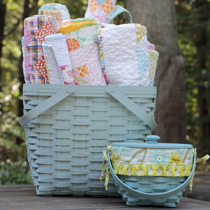 a basket filled with lots of different types of blankets and diapers sitting on top of a wooden table