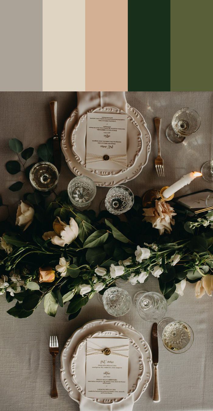 the table is set with plates, silverware and flowers