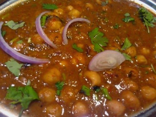 a metal pan filled with chickpeas and onions