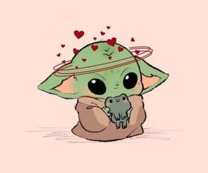 a baby yoda with hearts on it's head holding a small object in its hands