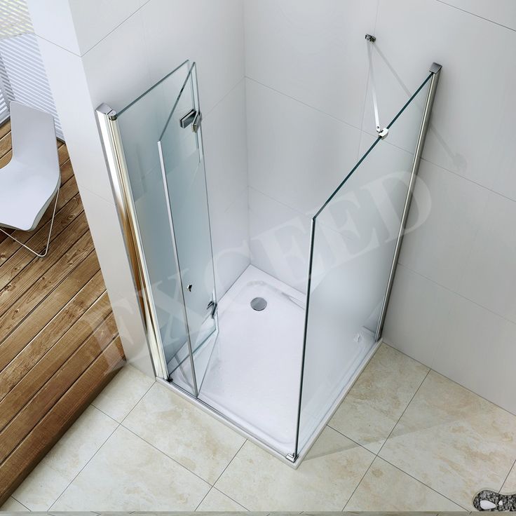 a bathroom with a glass shower stall and tiled floor