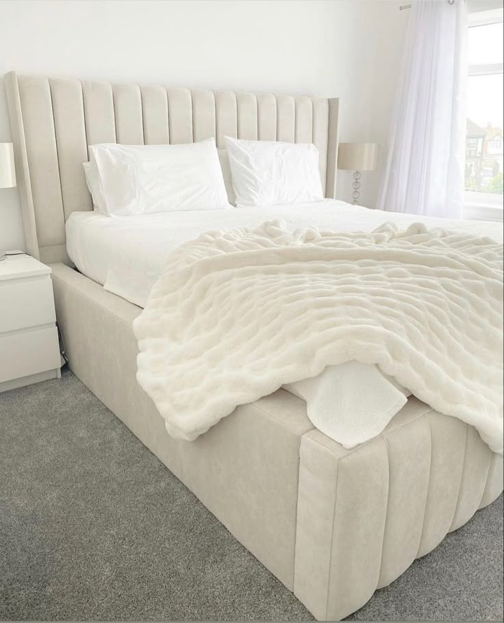 a large bed with white sheets and pillows