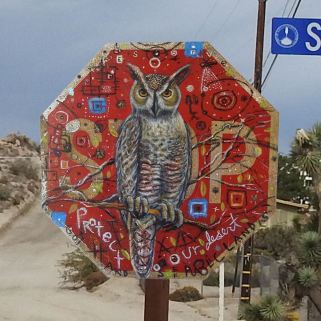 a stop sign with an owl painted on it