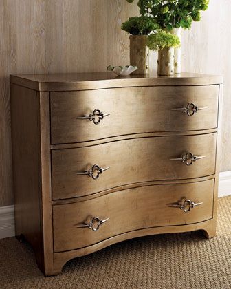 a wooden dresser with flowers in a vase on it's top and bottom drawer