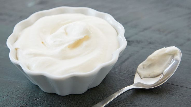 a spoon and bowl filled with yogurt on a table