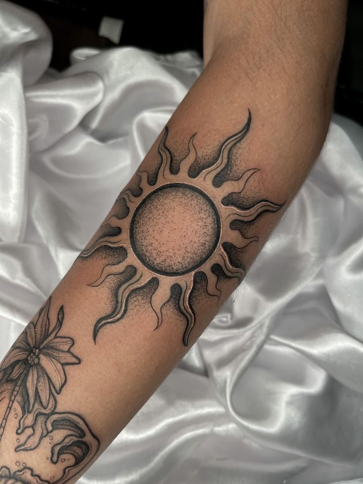 a person with a sun tattoo on their arm