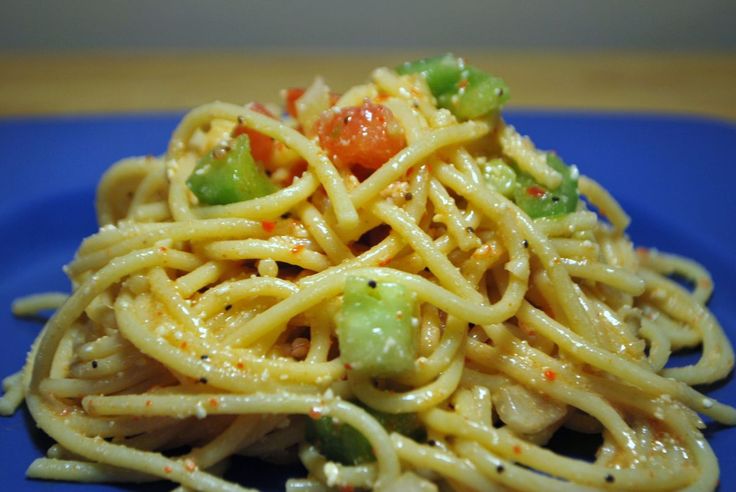 a blue plate topped with pasta and vegetables