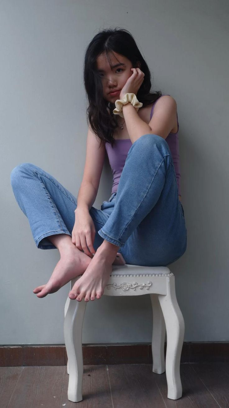 a woman sitting on top of a white chair