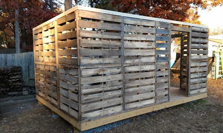 a wooden structure made out of pallets in the yard