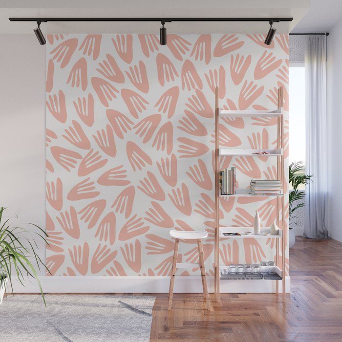 a pink and white wall mural with hand prints