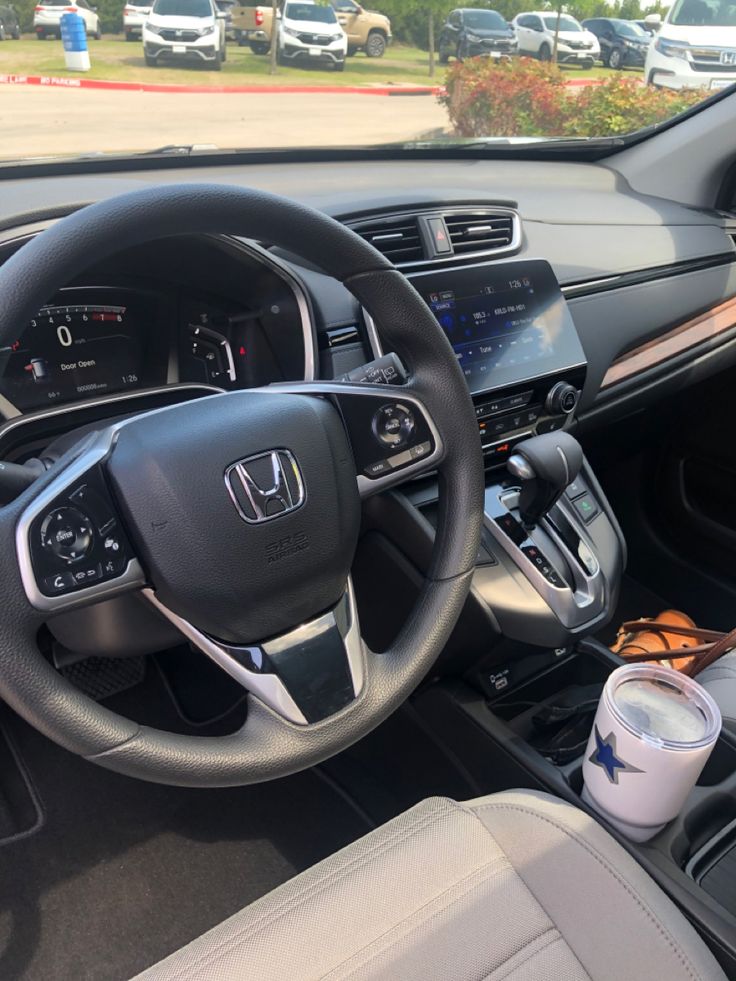 the interior of a car with steering wheel, dash board and dashboard controls on display