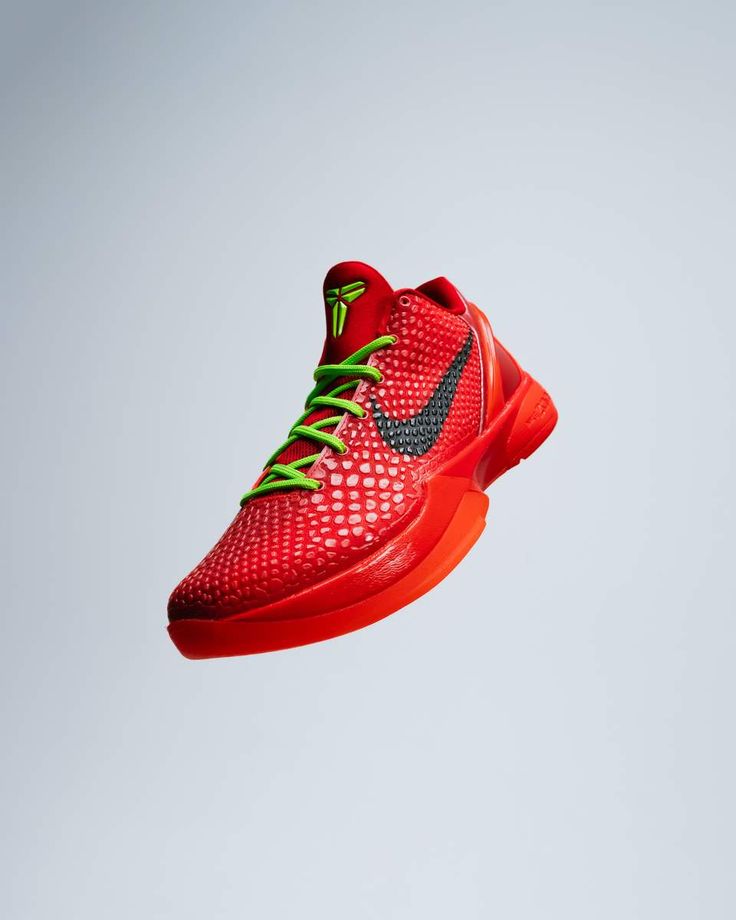 the shoe is flying through the air in red and green color scheme with white background