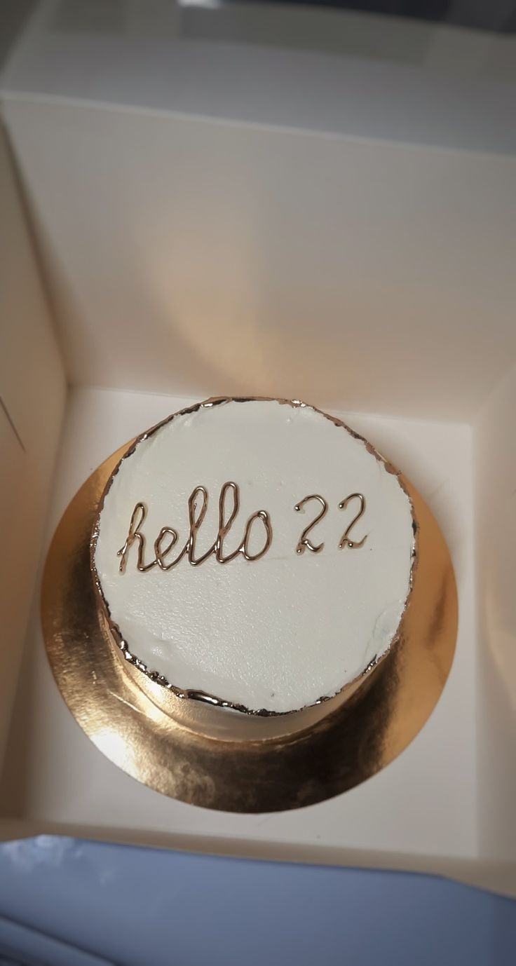 a cake with the word hello 22 written on it in gold and white frosting