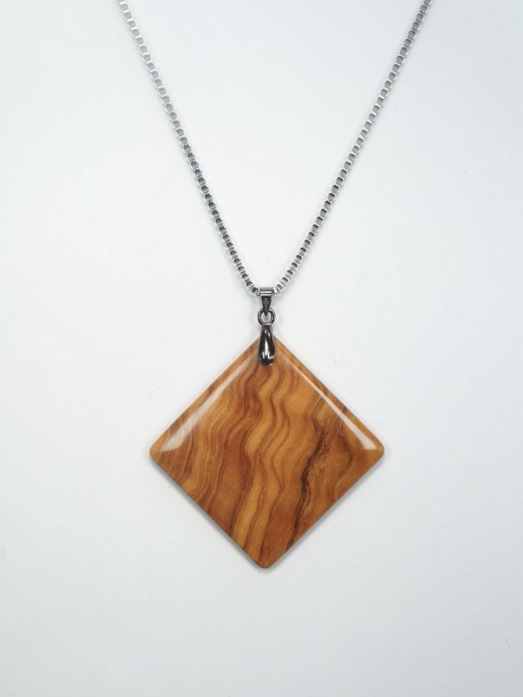 a necklace with a wooden pendant hanging from it's side