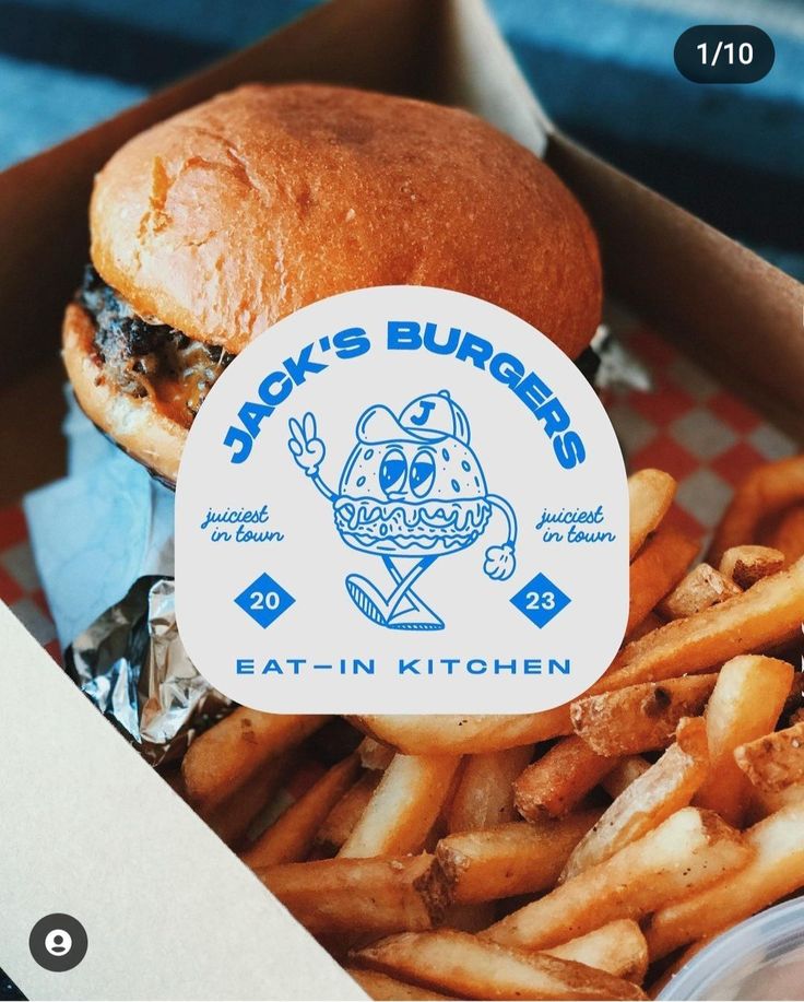 a close up of a sandwich and french fries in a box with the words jack's burgers on it