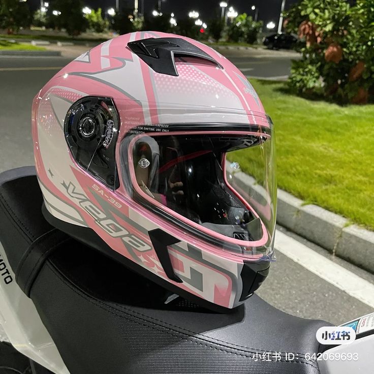 a helmet is sitting on the seat of a motor scooter in front of a street