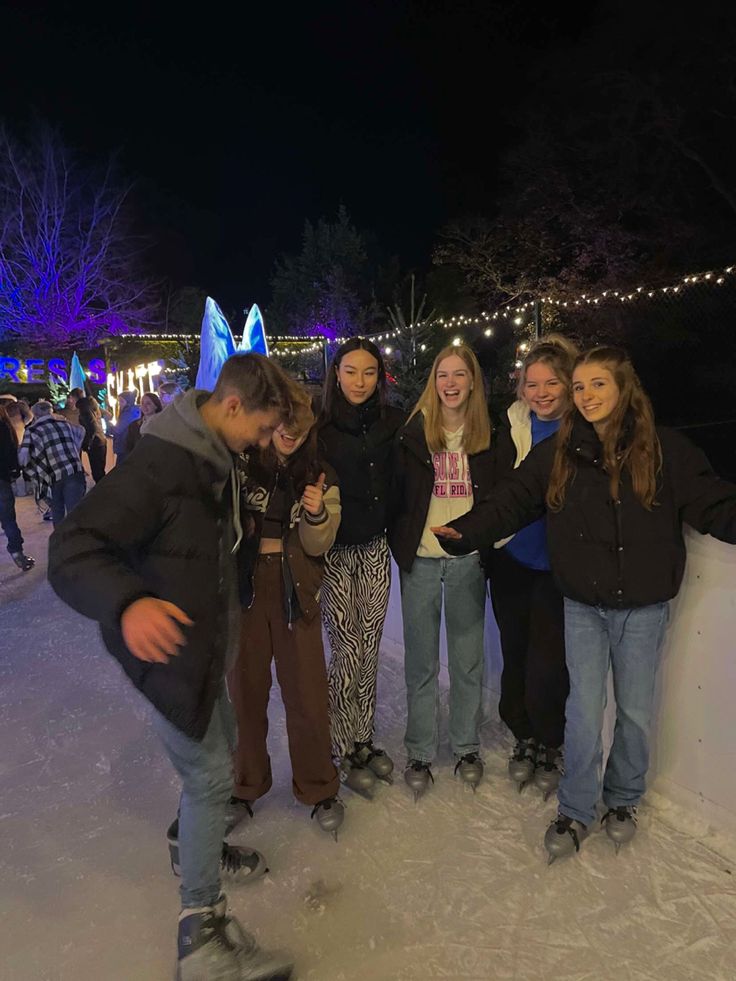 a group of young people standing next to each other on top of snow covered ground