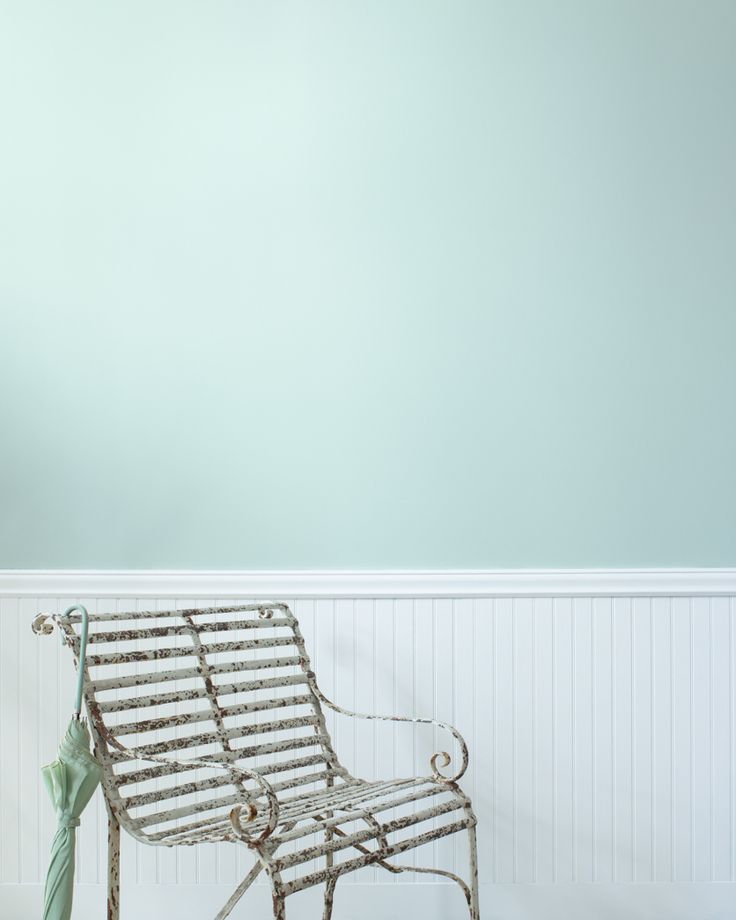 a metal bench sitting in the corner of a room next to a wall with blue paint on it