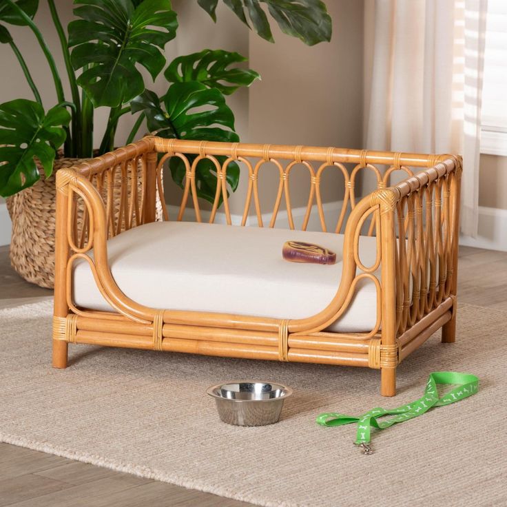 a dog bed with a bowl and green scissors on the floor next to it,