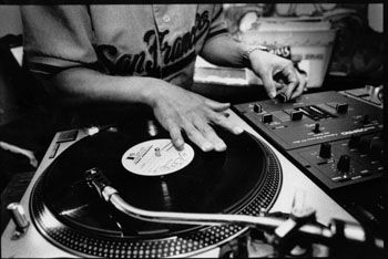 a man that is sitting at a dj's turntable with his hands on it