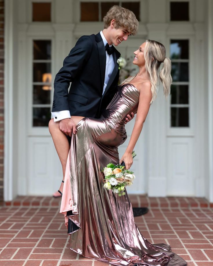 a man in a tuxedo leaning on the back of a woman's dress