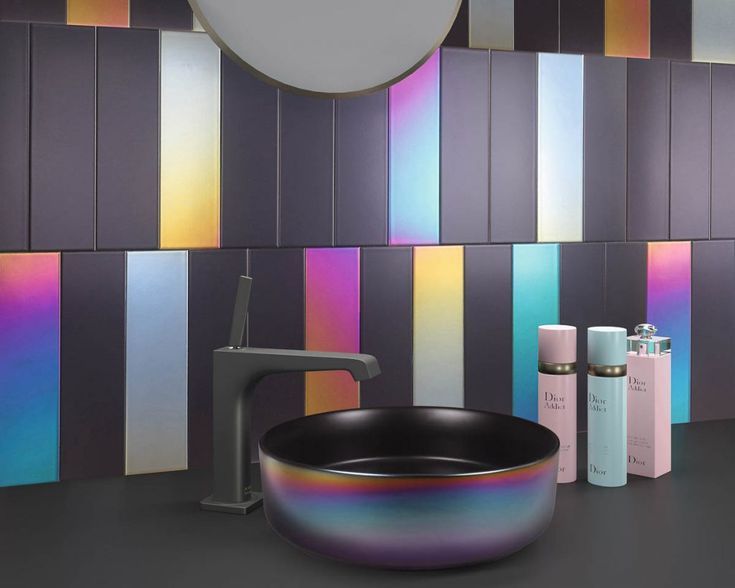 a black bowl sitting on top of a counter next to a faucet and soap dispenser