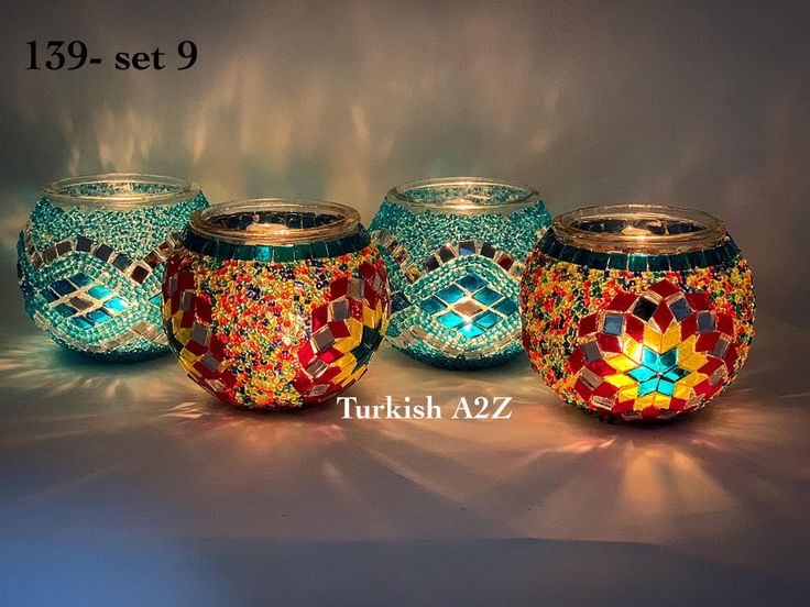 there are three glass jars with mosaic designs on them, one is blue and the other is red