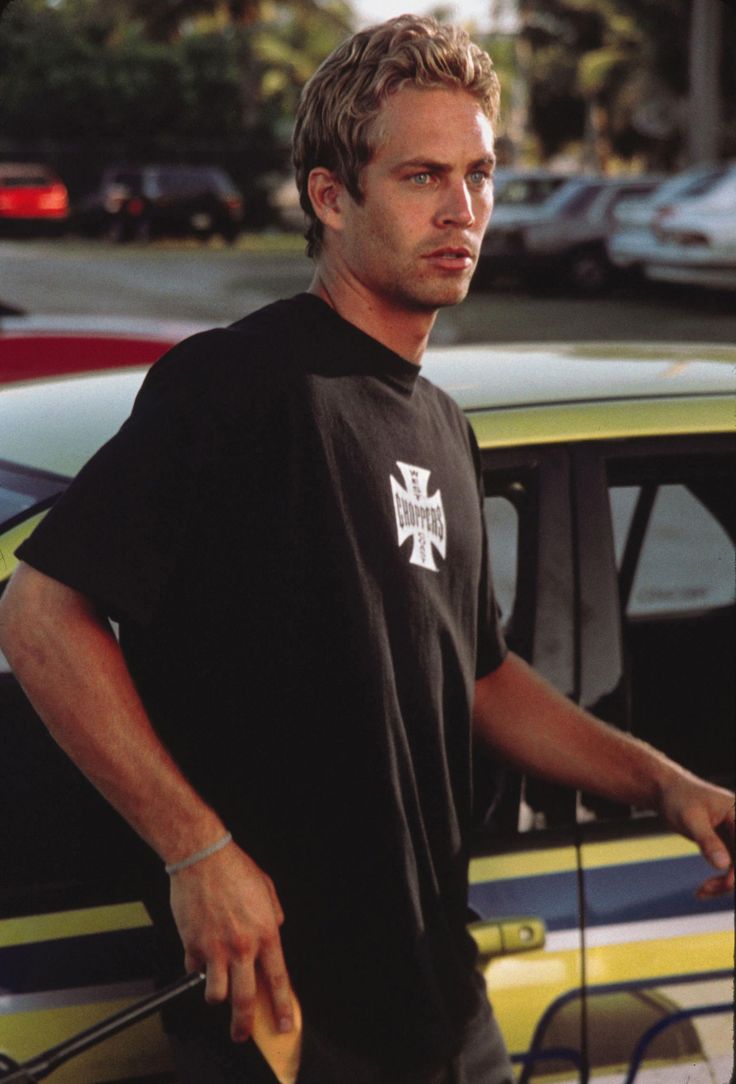 a man standing next to a yellow car