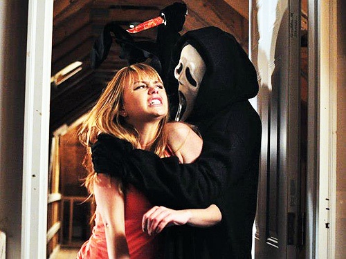 a man and woman dressed up in halloween costumes hugging each other while standing next to an open door