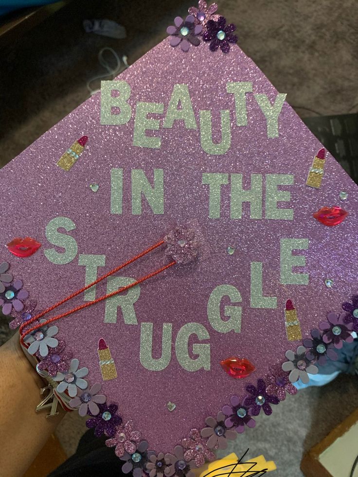 a purple graduation cap that says beauty in the struggle on it with flowers and beads