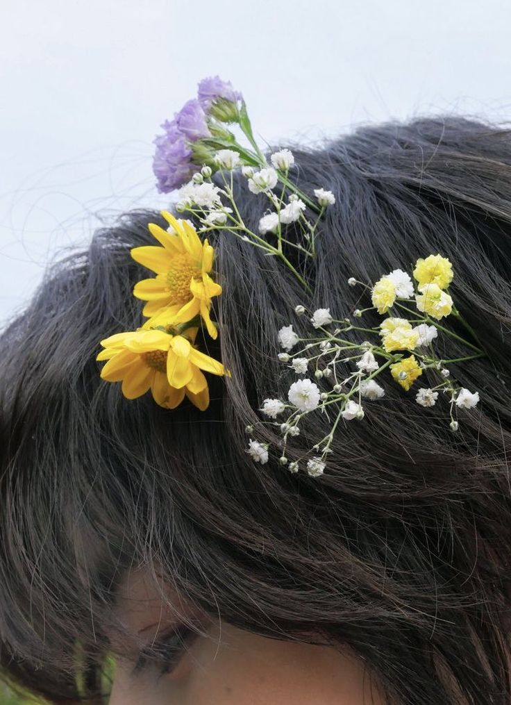 a close up of a woman with flowers in her hair and wearing a flower crown