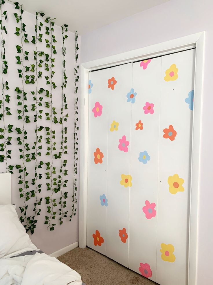 a white door with colorful flowers painted on it in a bedroom next to a bed