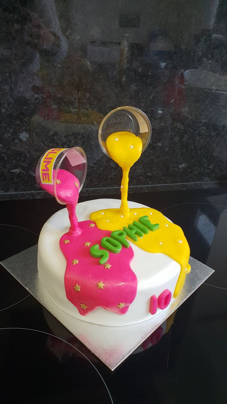 there is a cake that has been decorated with yellow and pink icing on it