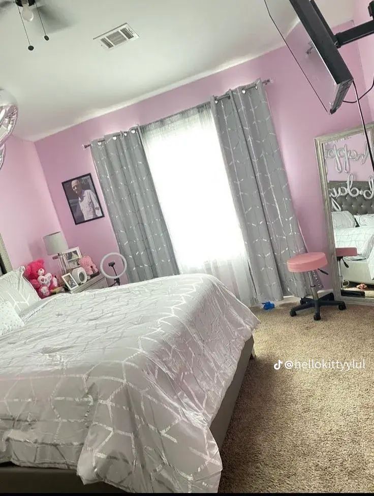 a bedroom with pink walls and white bedding