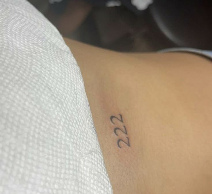 a woman with a small tattoo on her left arm and the number 53 written in black ink