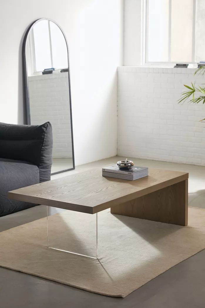 a living room with a couch, mirror and coffee table